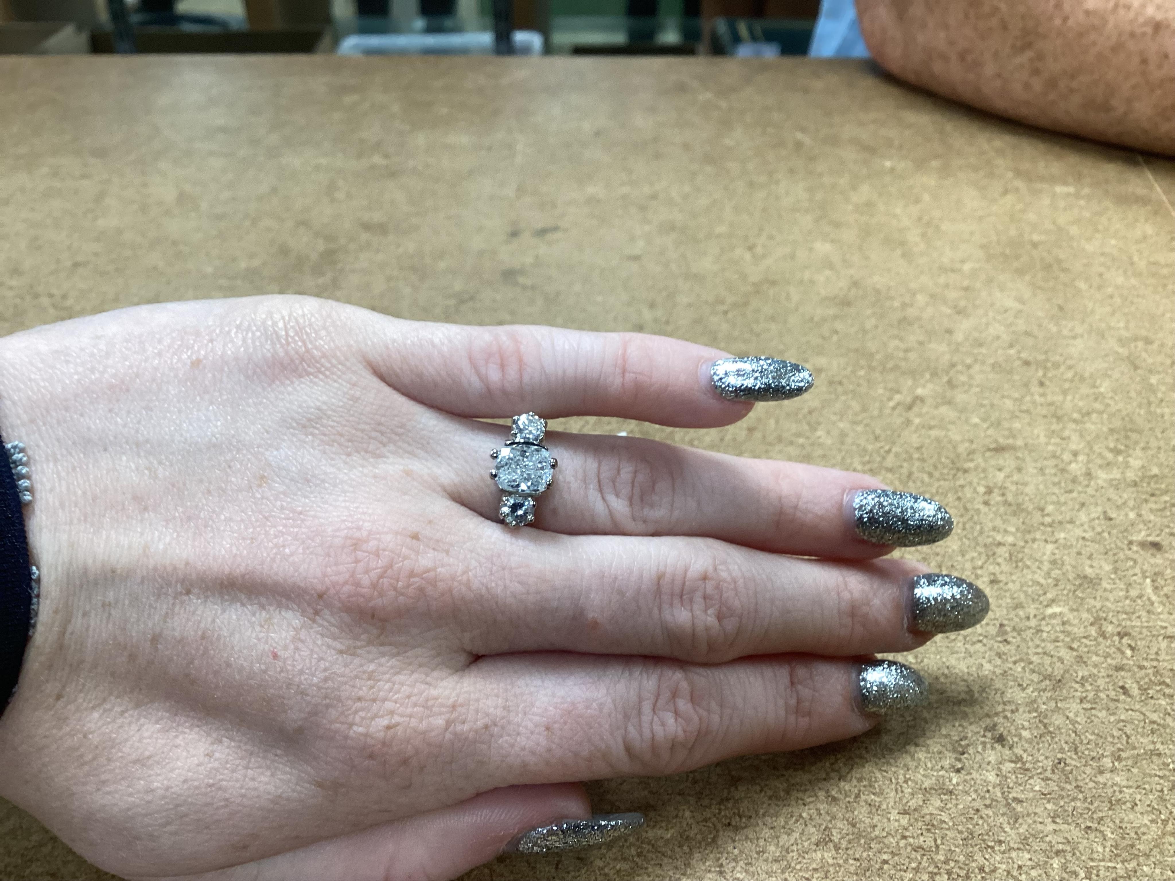 A diamond ring, set with a cushion-shaped diamond weighing 1.50 carats, between shoulders set with brilliant-cut diamonds totalling approximately 0.40 carats, size K, gross weight approximately 4 grams, Condition: centra